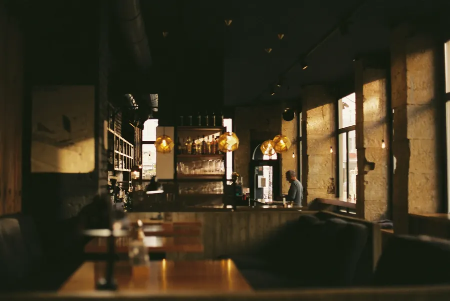 Sala restauracji wieczorem, ciepłe światło lamp nad barem